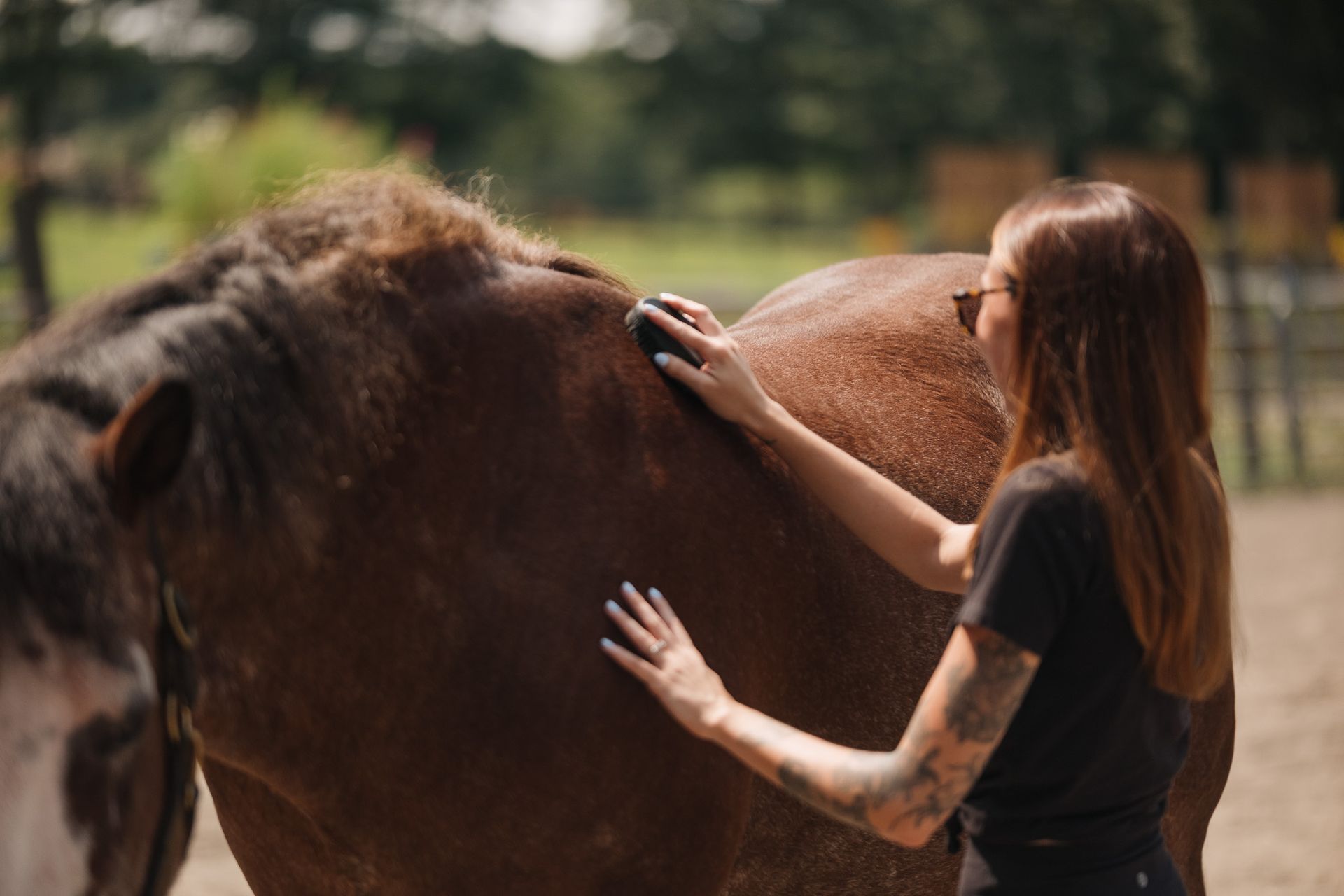 A woman is standing next to a child riding a horse