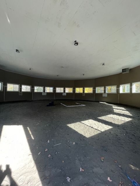 Circular riding ring with many small windows, sunlight streaming in.