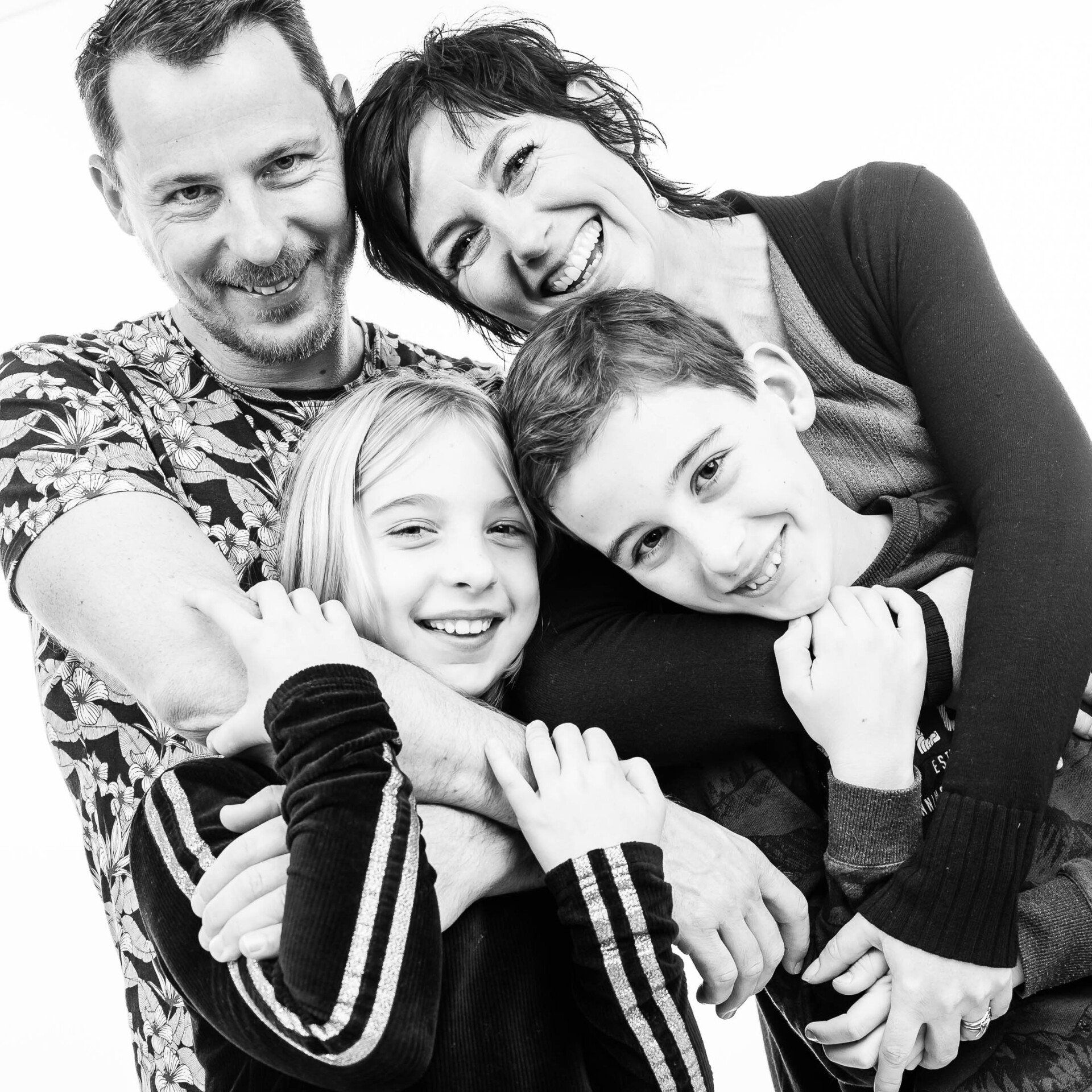 Een zwart-witfoto van een gezin dat elkaar omhelst