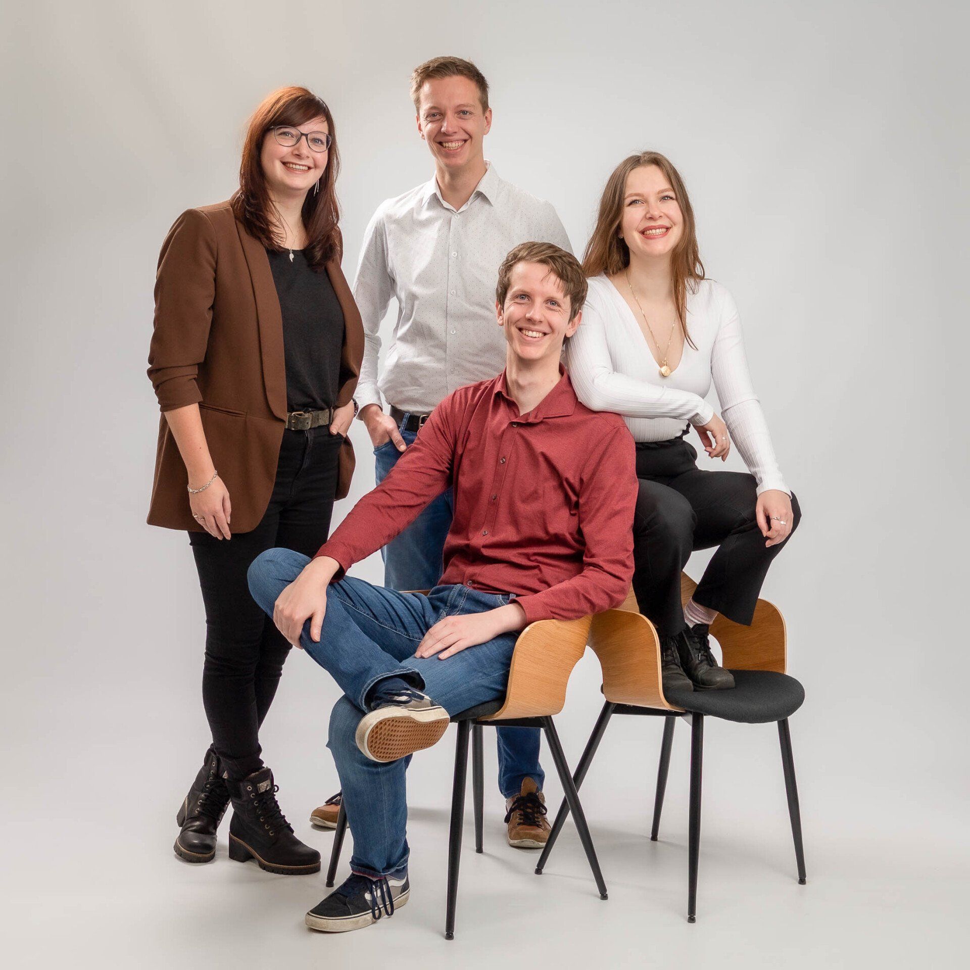 Een groep mensen poseert voor een foto terwijl ze op stoelen zitten.