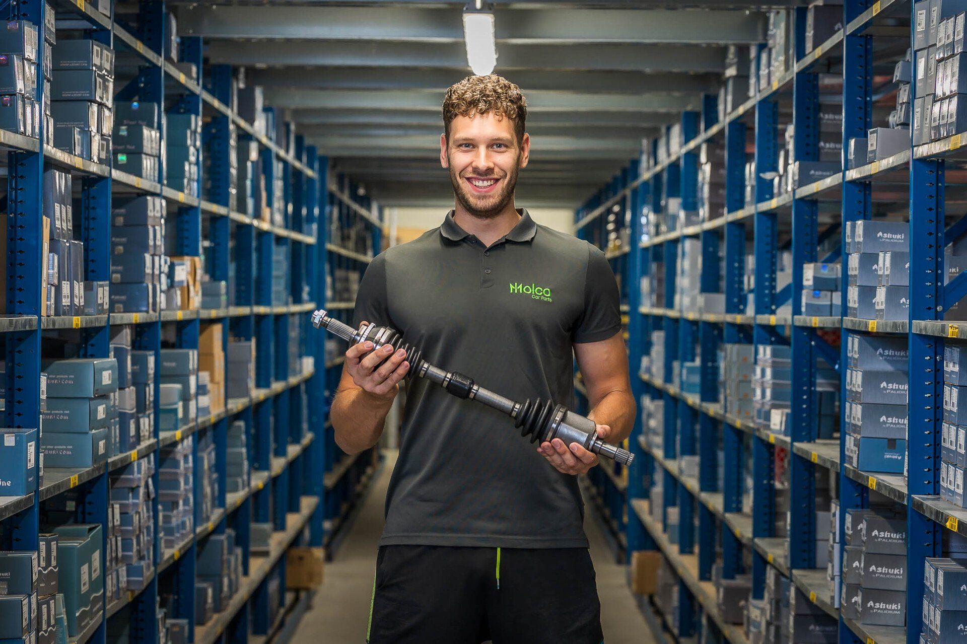 Een man houdt een as vast in een pakhuis.