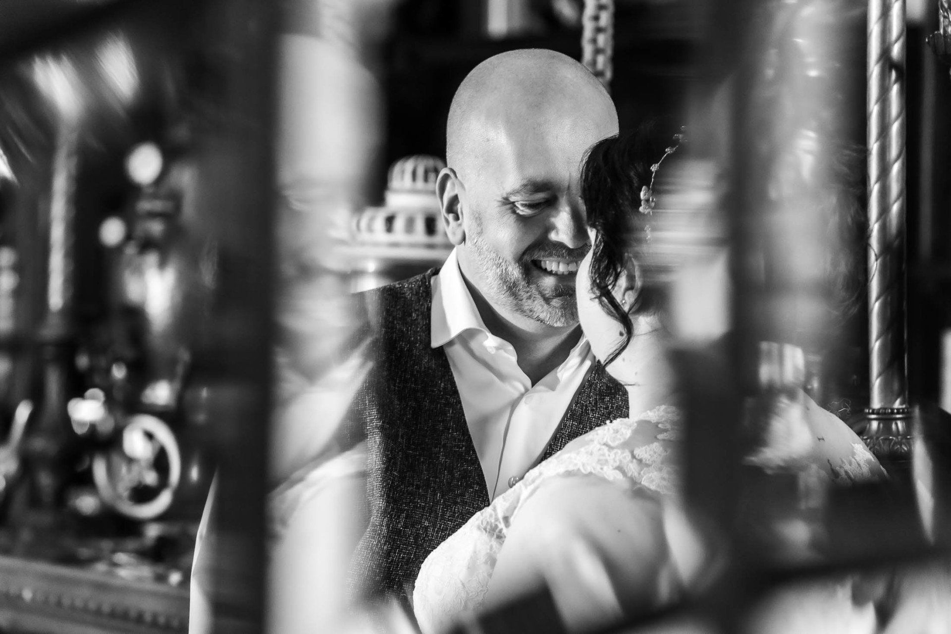 Op een zwart-witfoto houdt een man een bruid in zijn armen.