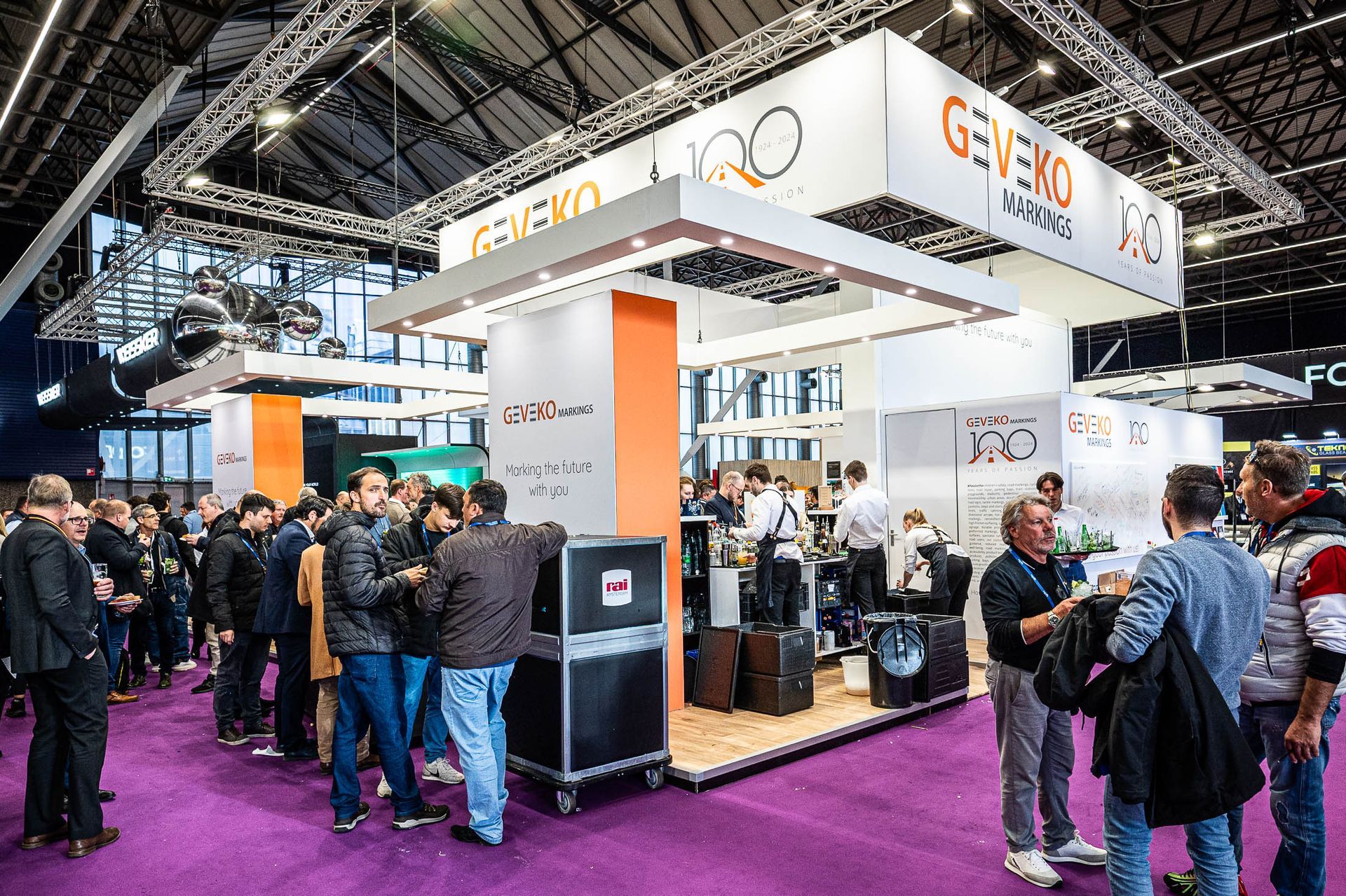 Een groep mensen staat rond een stand op een congres.