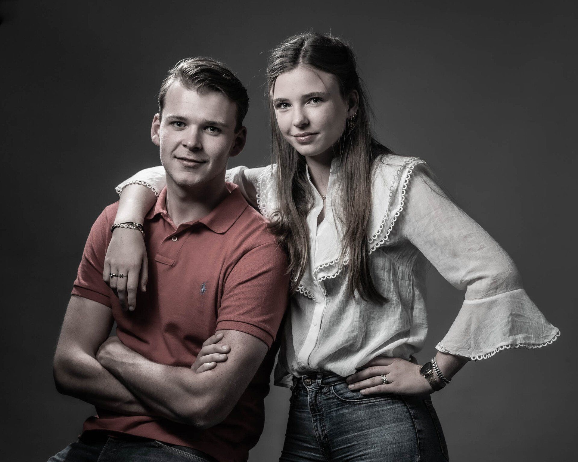 Een man en een vrouw poseren voor een foto met hun armen over elkaar.