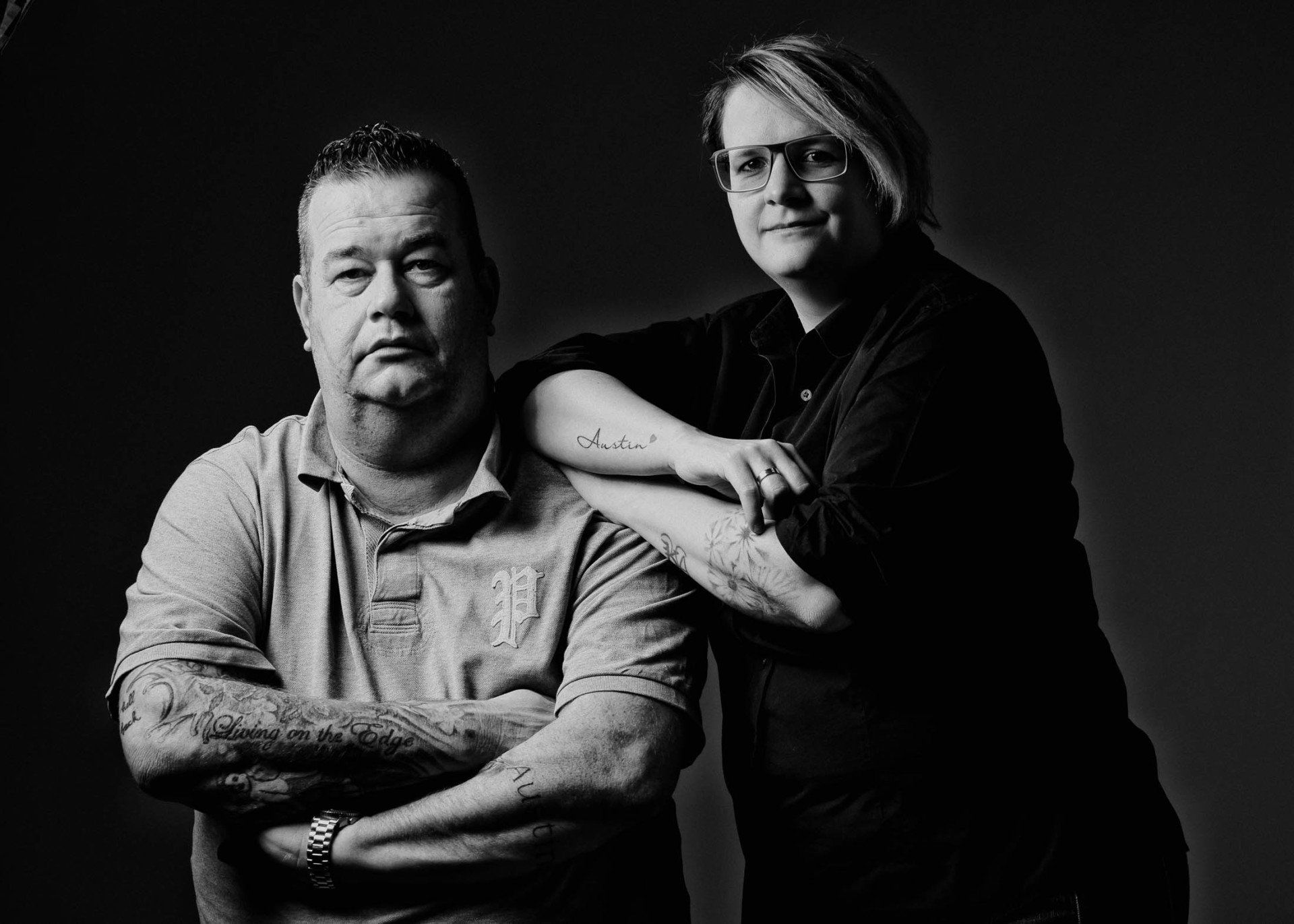 Een man en een vrouw staan naast elkaar met hun armen over elkaar.