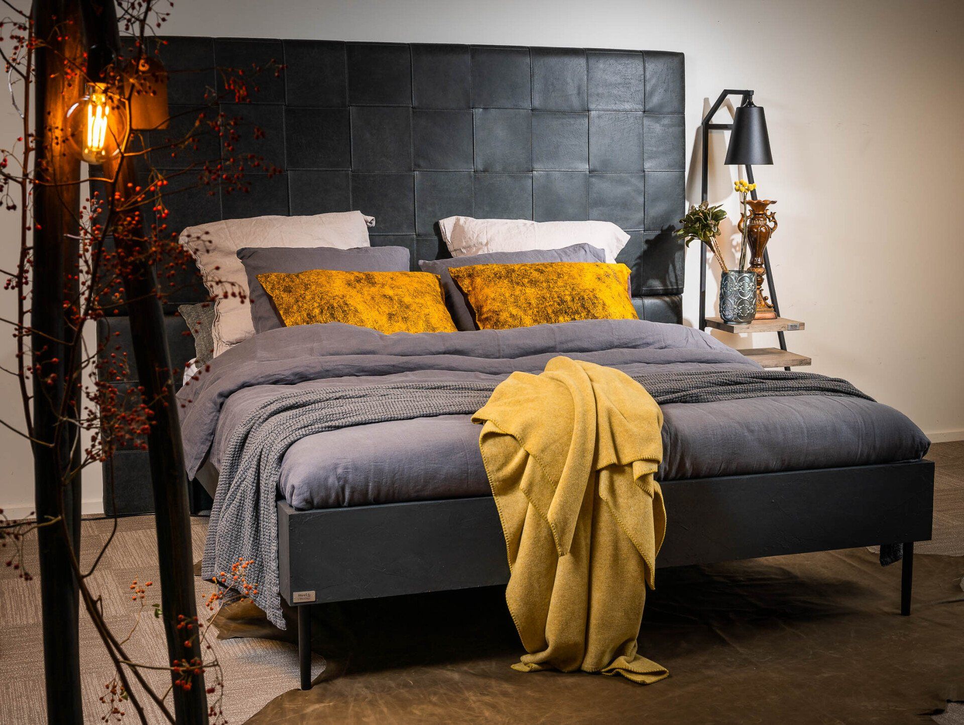 Een bed met een gele deken erop in een slaapkamer.