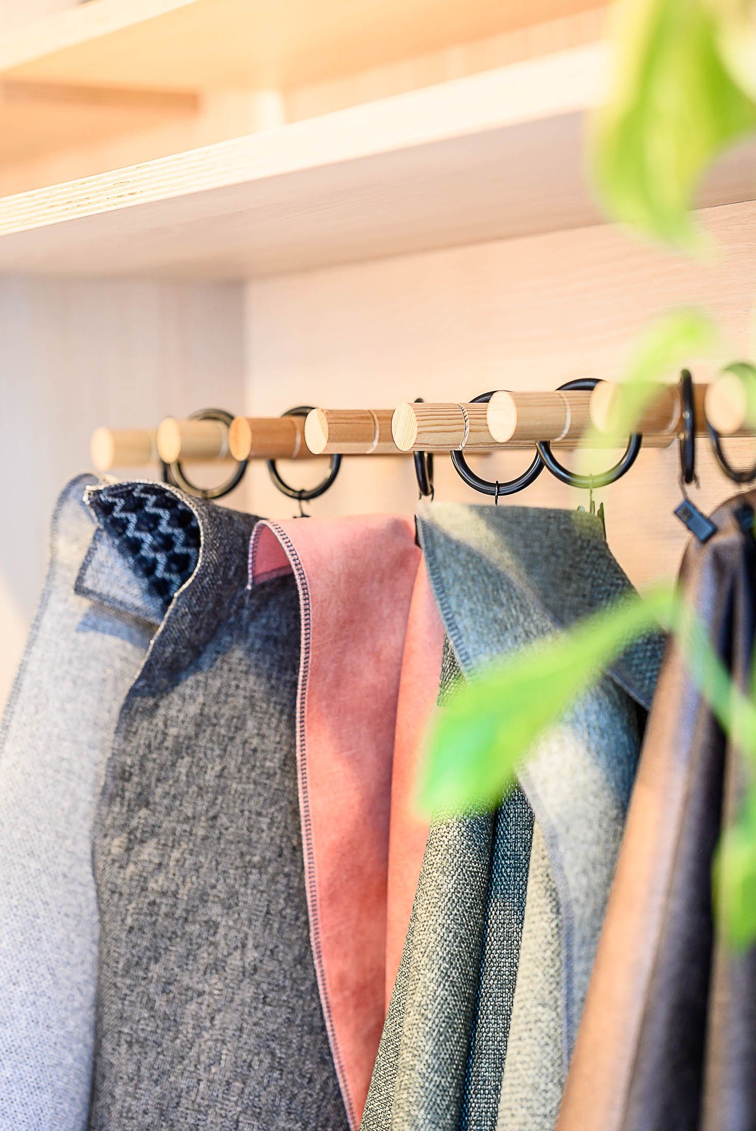 Er hangt een stapel kleding aan een rek in een kast.