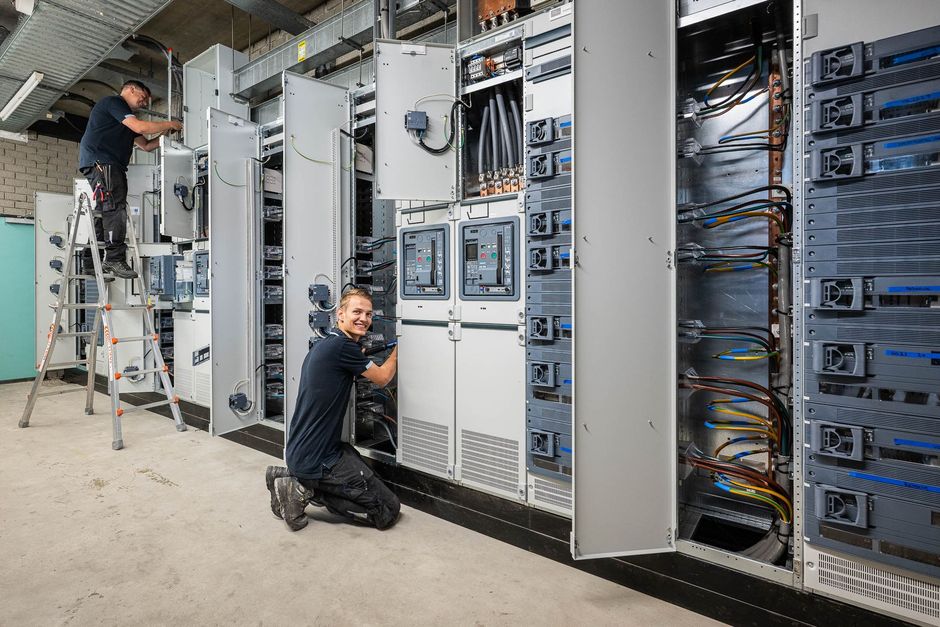 Een vrouw in een rood shirt houdt een foto van zichzelf in haar handen.