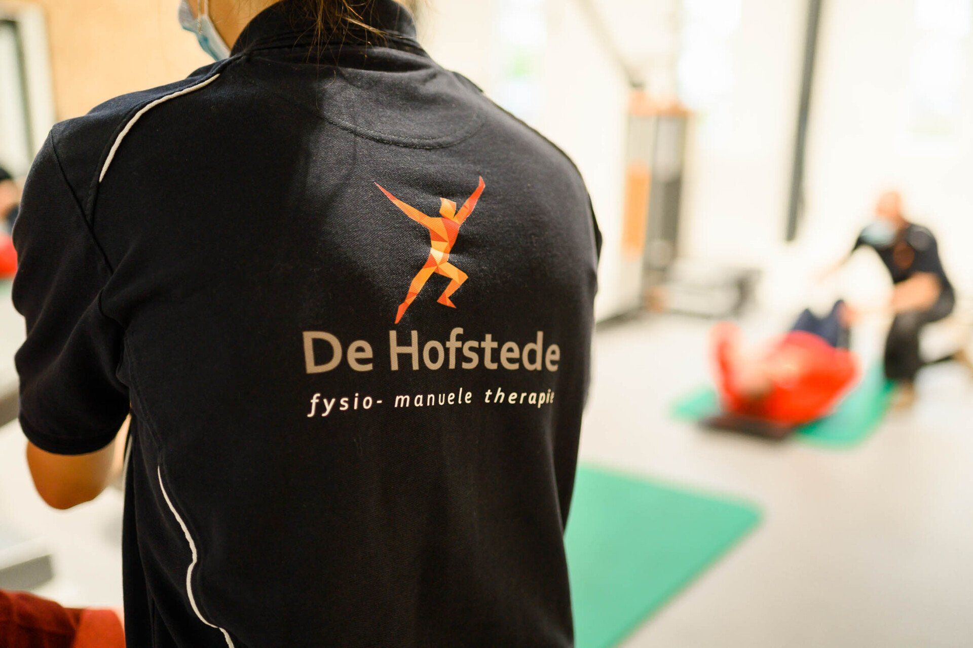 Een persoon die een shirt draagt met de tekst 'de hofstede' erop