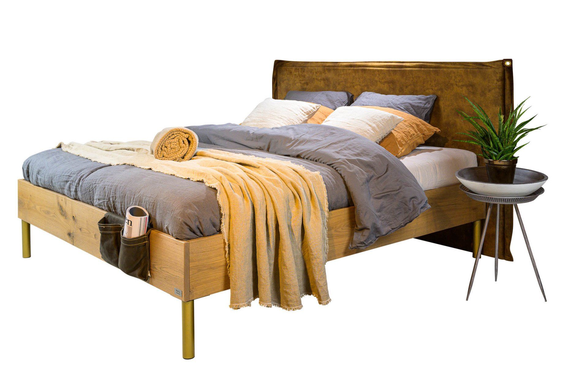 Een bed met een deken en kussens erop en een nachtkastje ernaast.