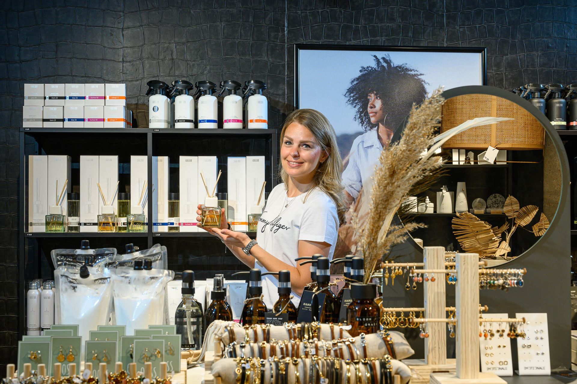 Een vrouw staat voor een etalage met sieraden in een winkel.