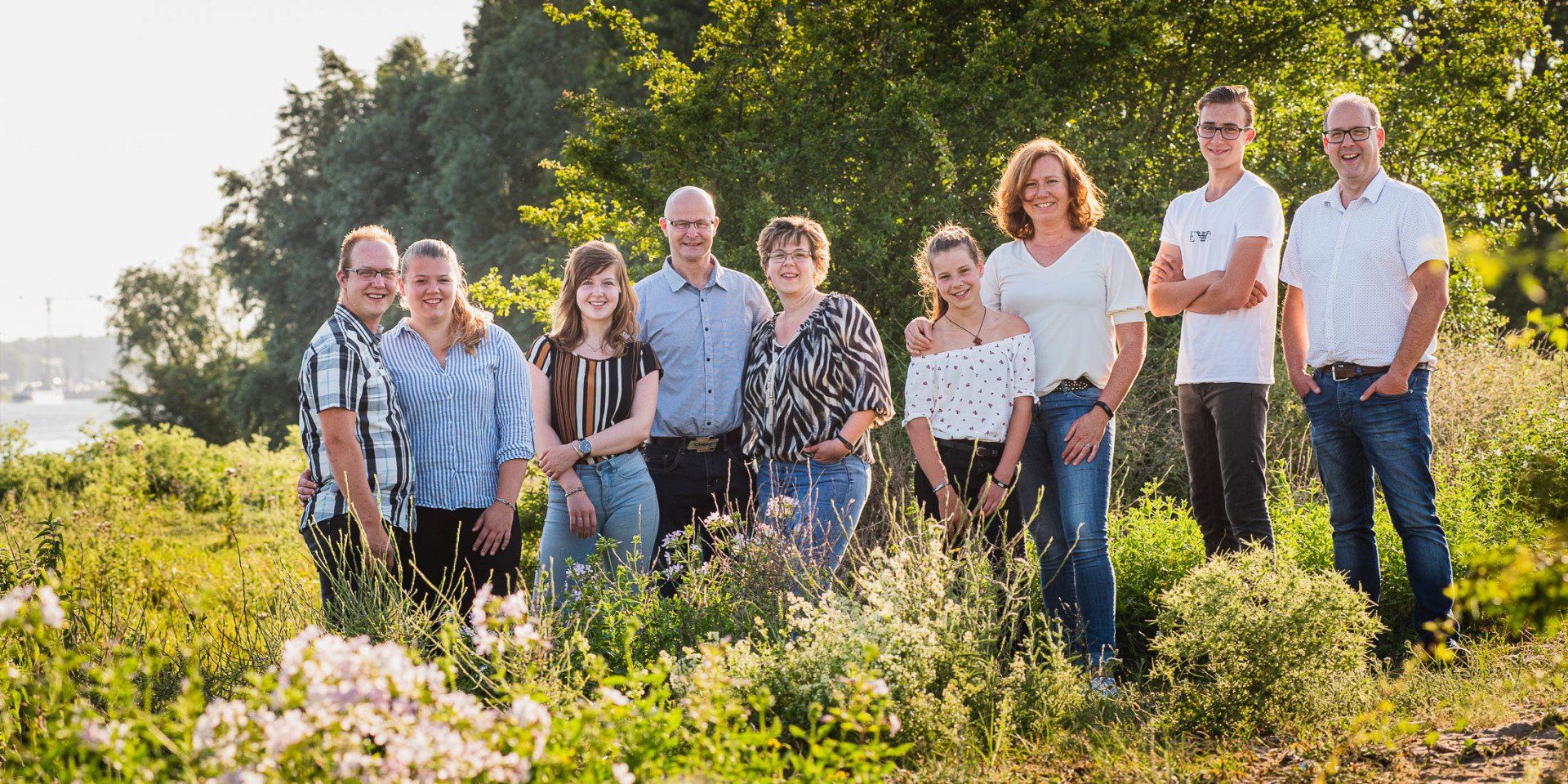 Een groep mensen poseert voor een foto in een veld.