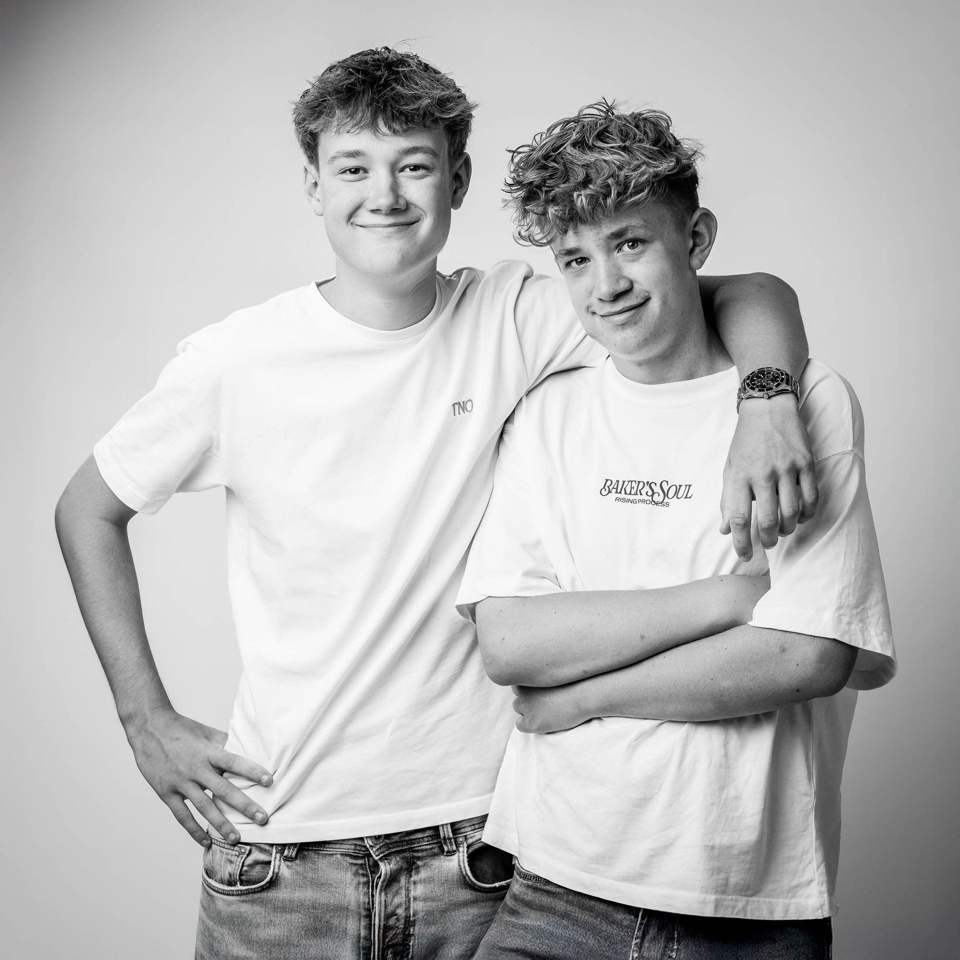 Een zwart-witfoto van twee jongens die naast elkaar staan.