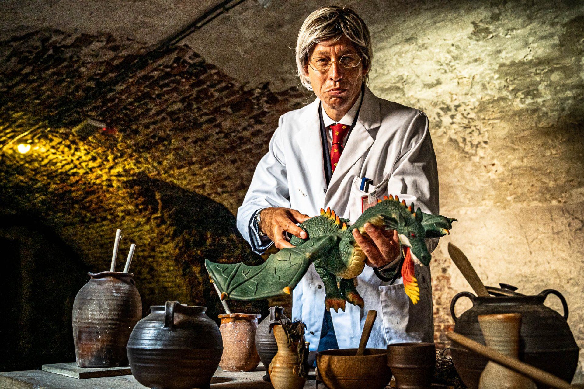 Een man in een laboratoriumjas houdt een draak in zijn handen.