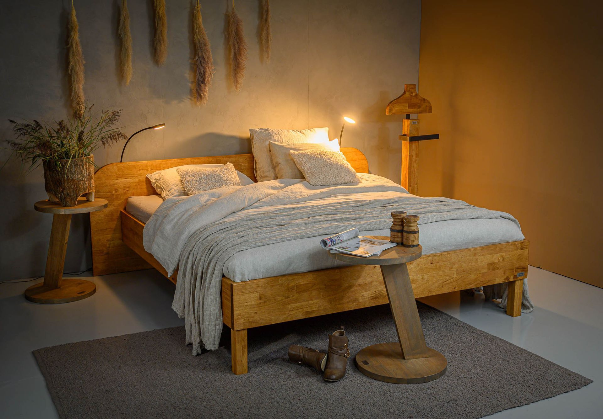 Een slaapkamer met een houten bed en een houten tafel.