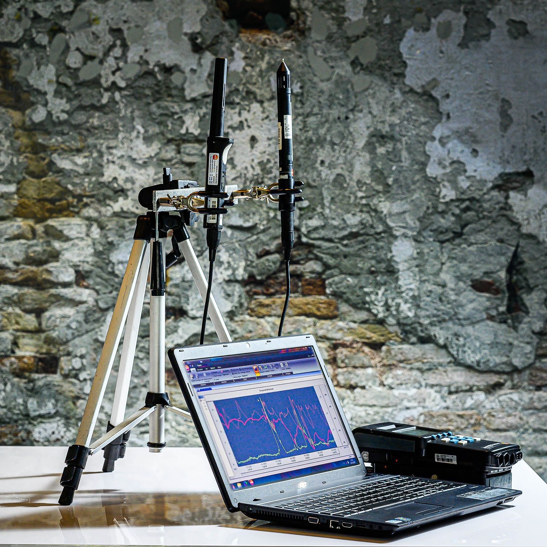 Een laptop staat op een tafel naast een statief