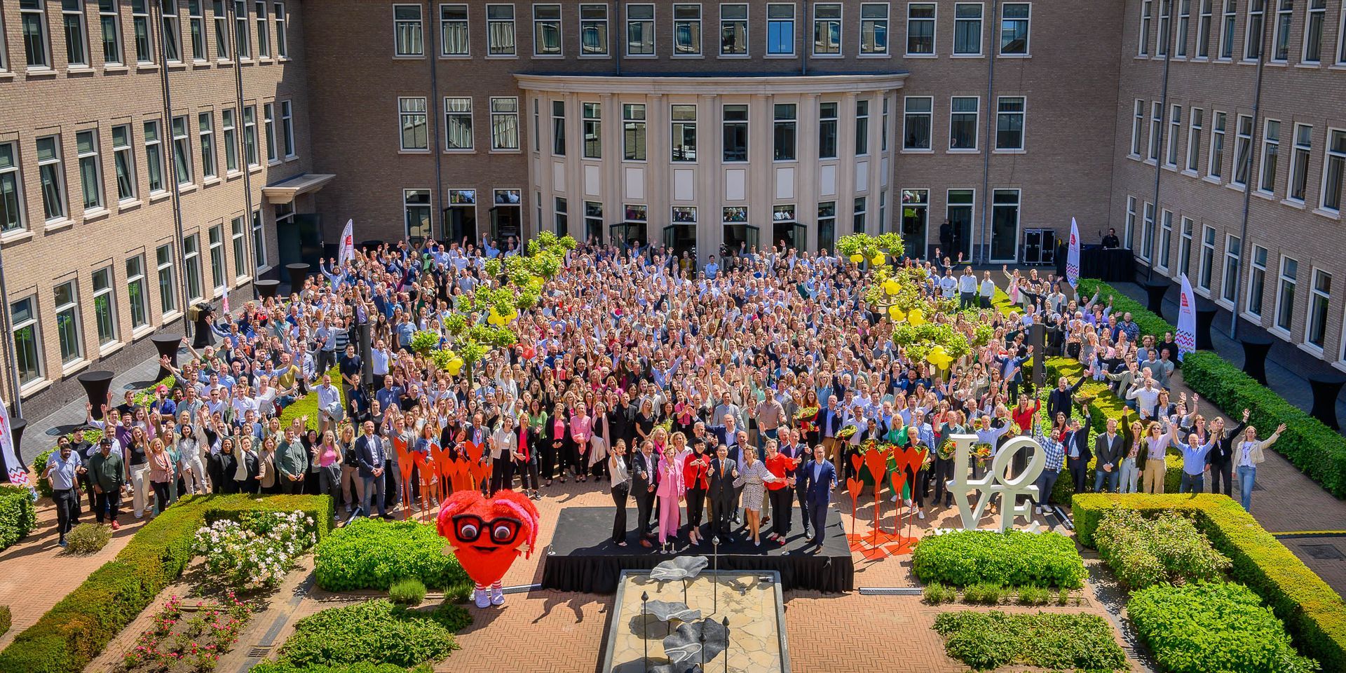 Een grote groep mensen staat voor een groot gebouw.