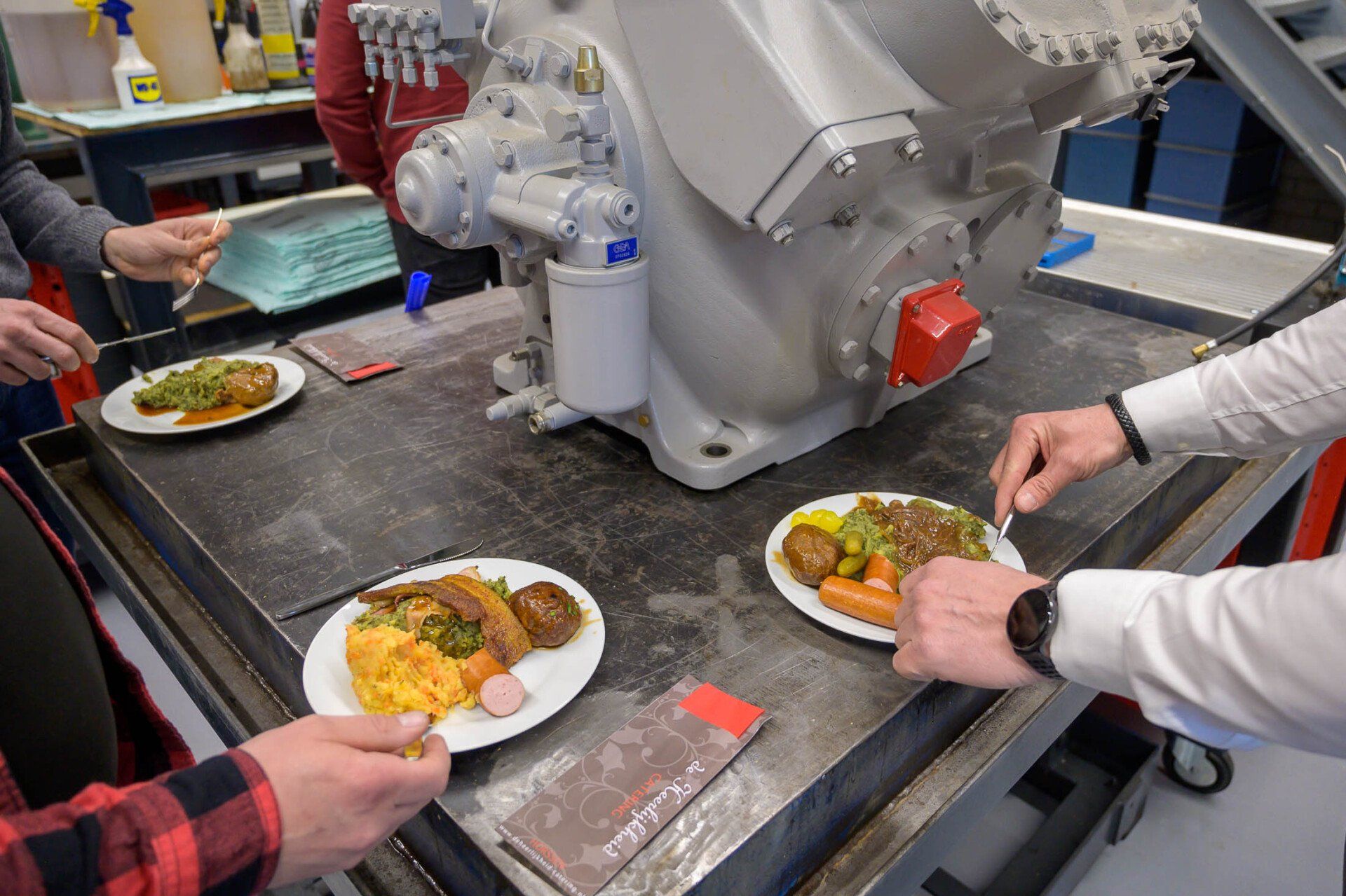 Een groep mensen eet borden vol eten voor een machine.