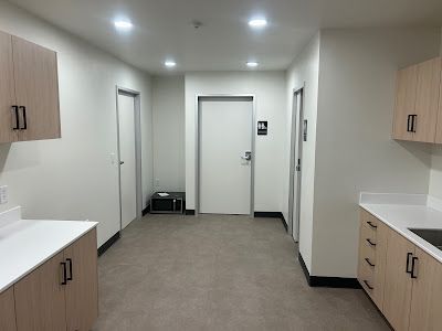 A bright, modern hallway with cabinets, doors, and a small appliance.