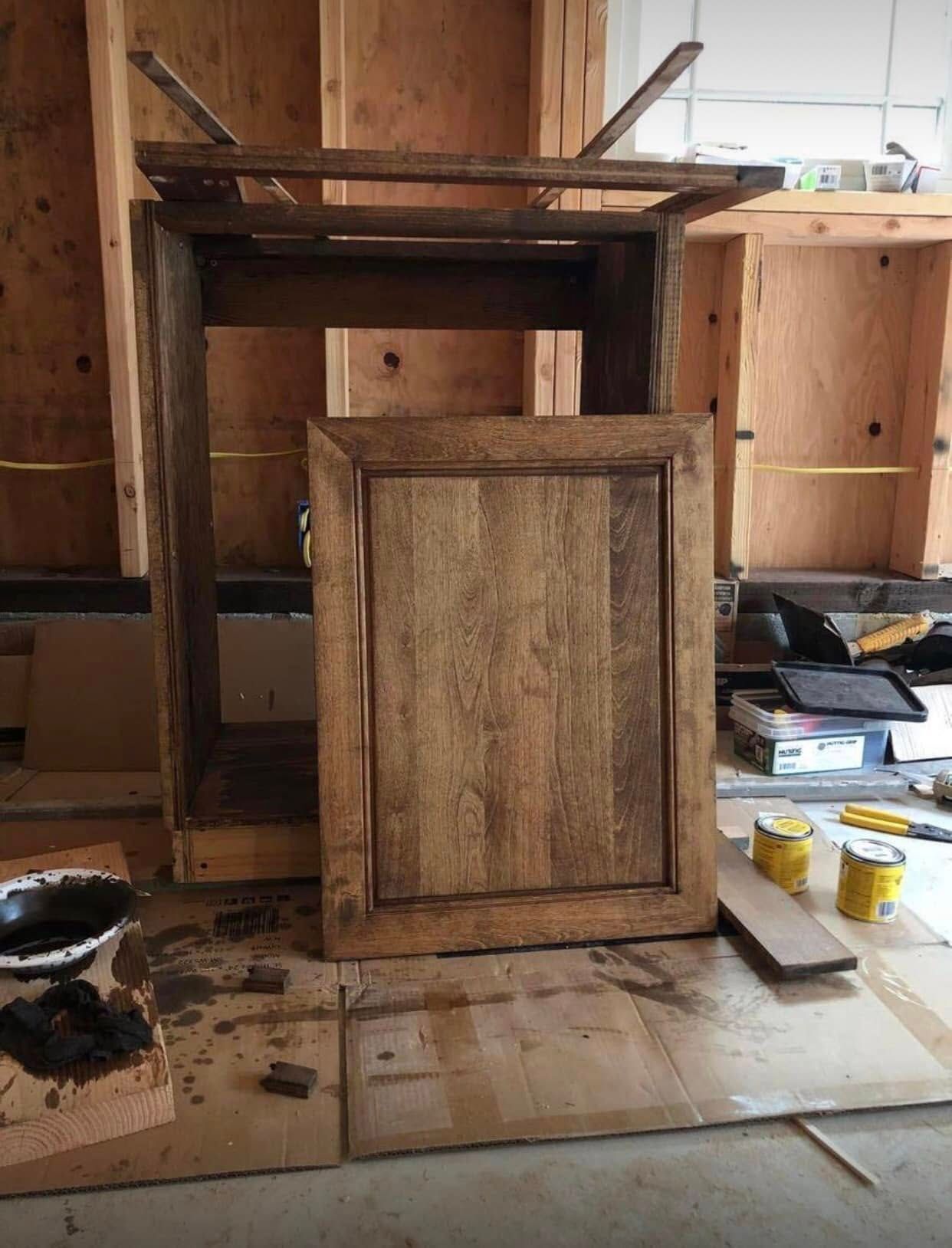 A man wearing a mask is holding a box of pizza