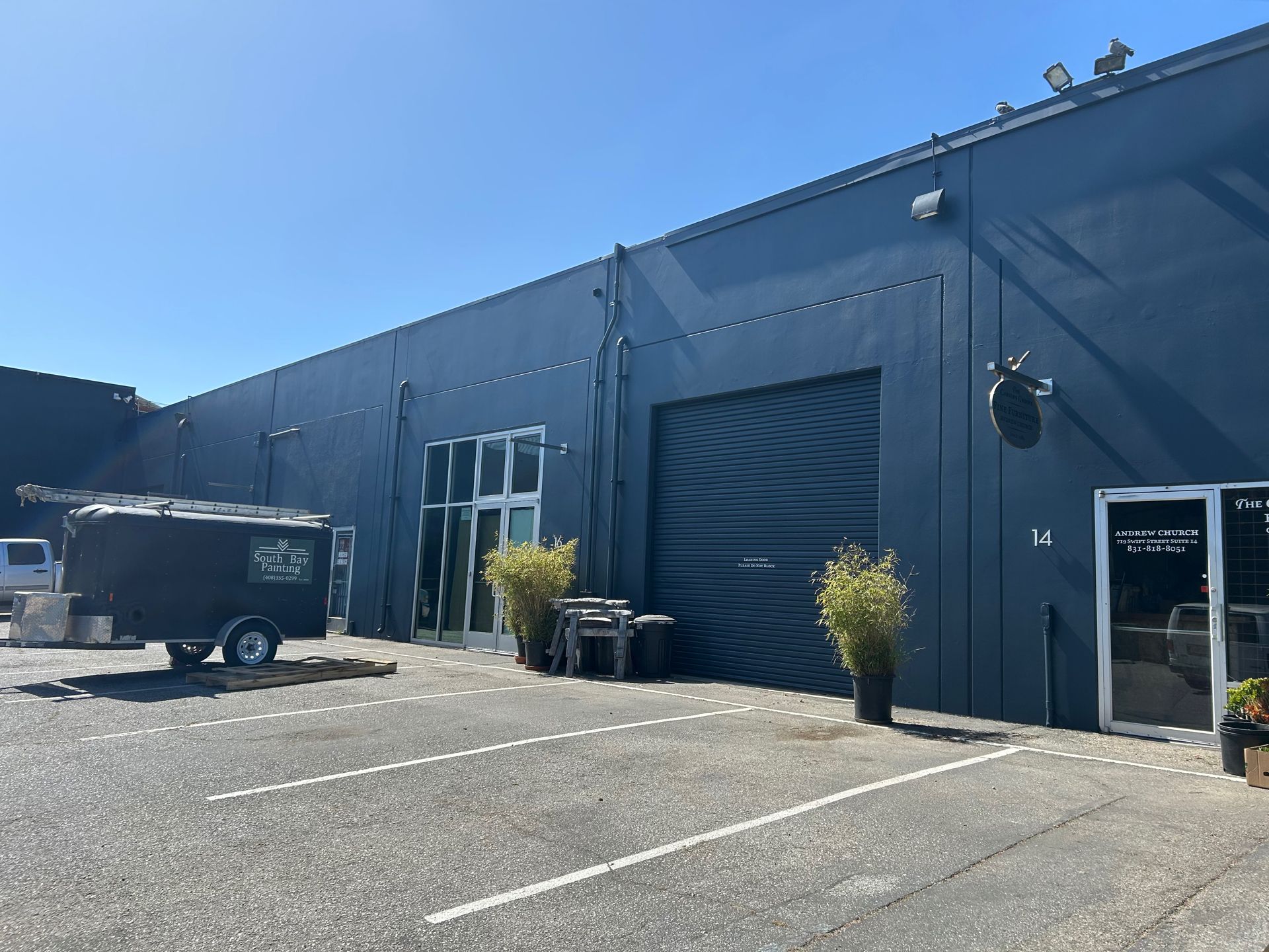 A delivery man in a red shirt is writing on a clipboard