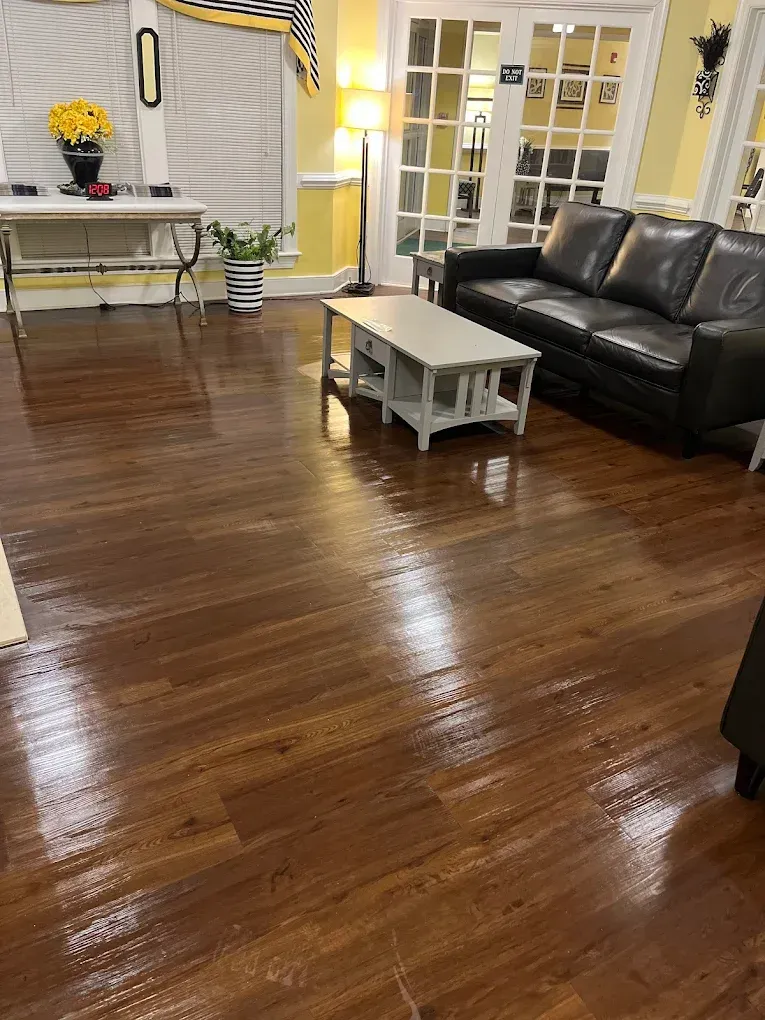 Wooden floor in a living room with a couch, table, and decorations.