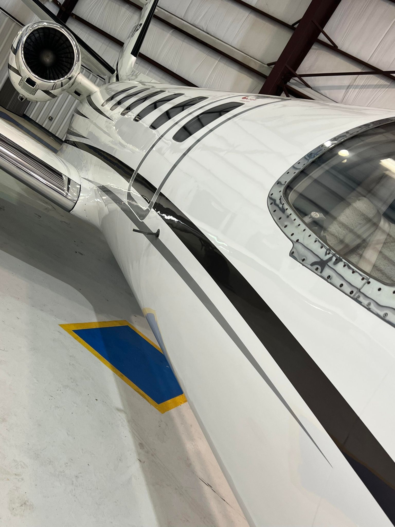 A white and black airplane is parked in a hangar.