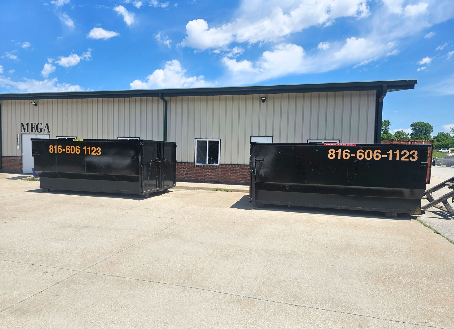 Outdoor scene with overflowing trash bins; debris scattered on the ground.