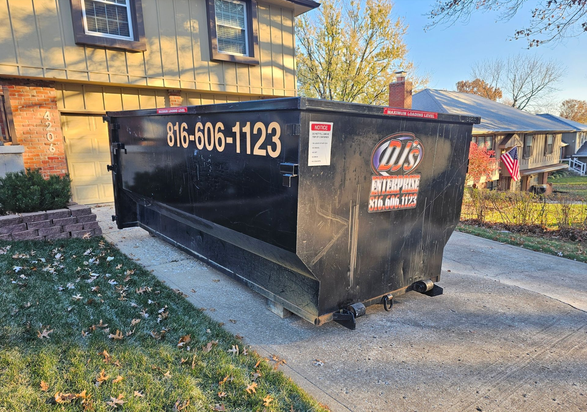 Blue dumpster on truck bed at construction site.