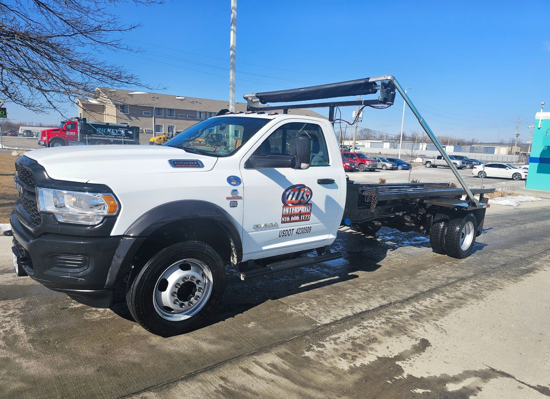 Construction dumpster filled with debris, on a dirt site, with a scaffolding background.