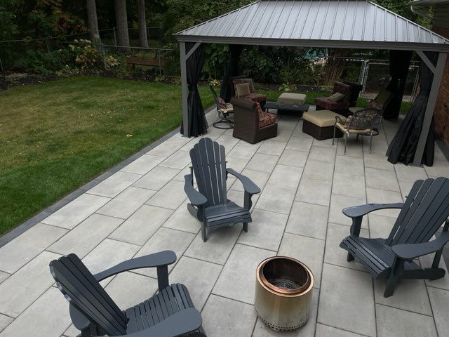 Backyard patio with fire pit, four chairs, and a gazebo seating area