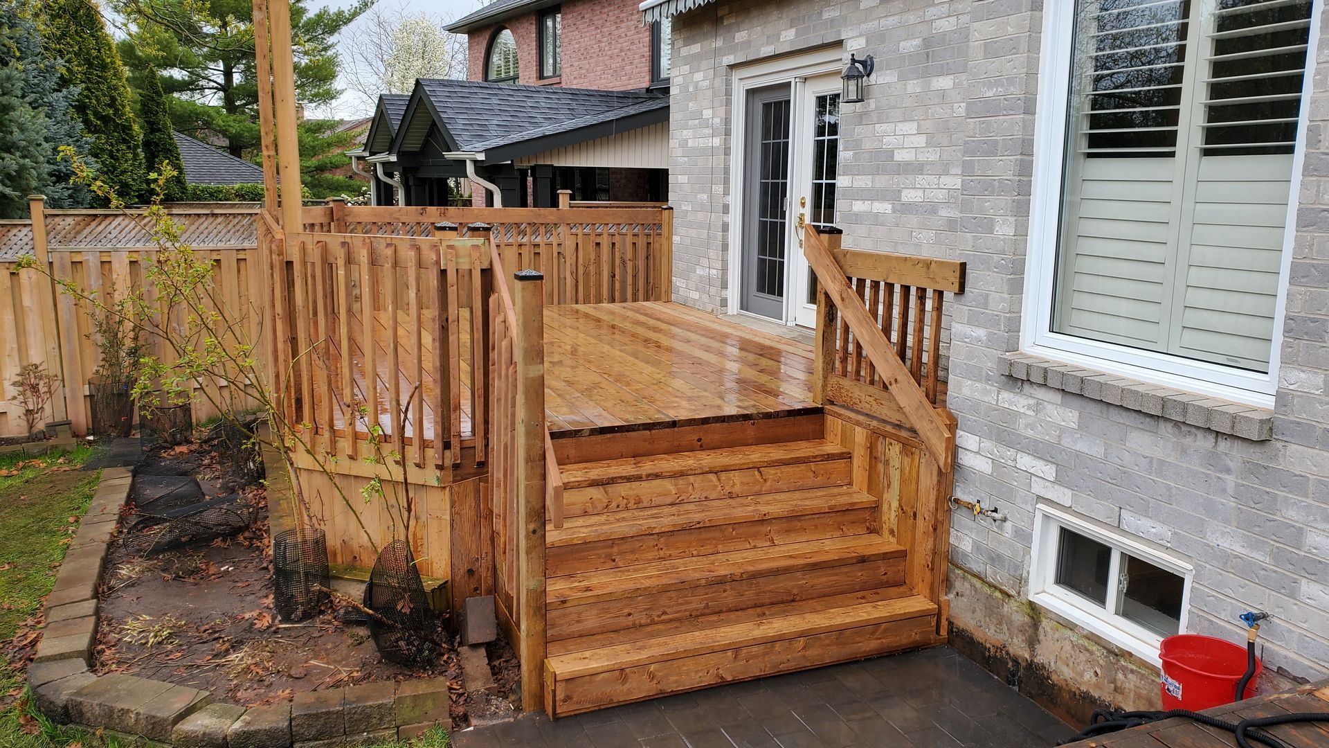 a wooden deck with stairs and a fence in front of a house .