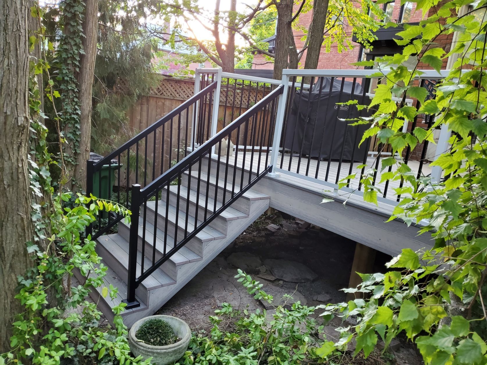 a set of stairs leading up to a deck surrounded by trees .