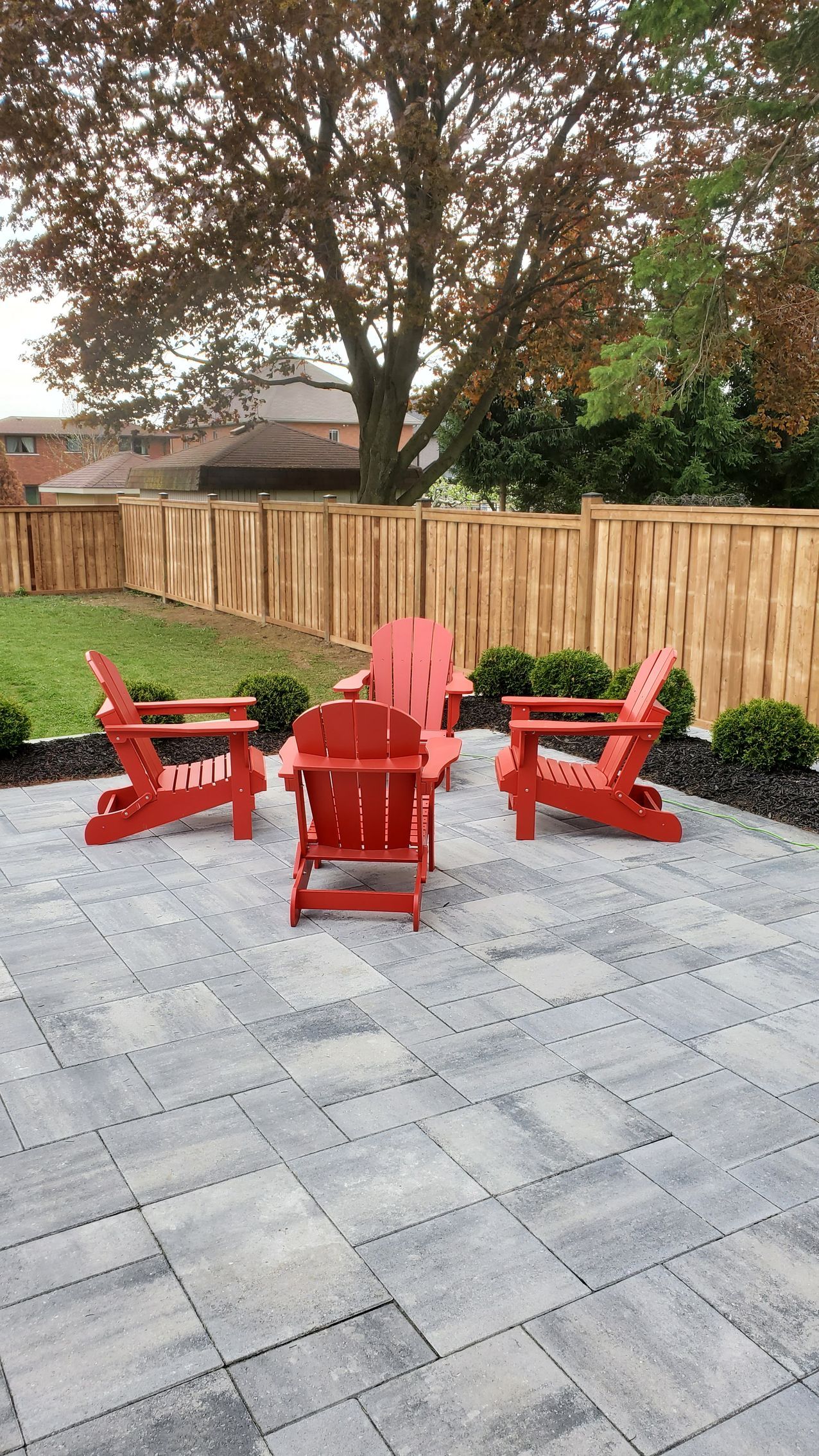 a patio with red chairs and a wooden fence .
