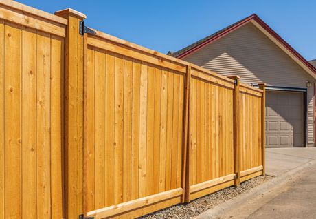 a wooden fence with a house in the background