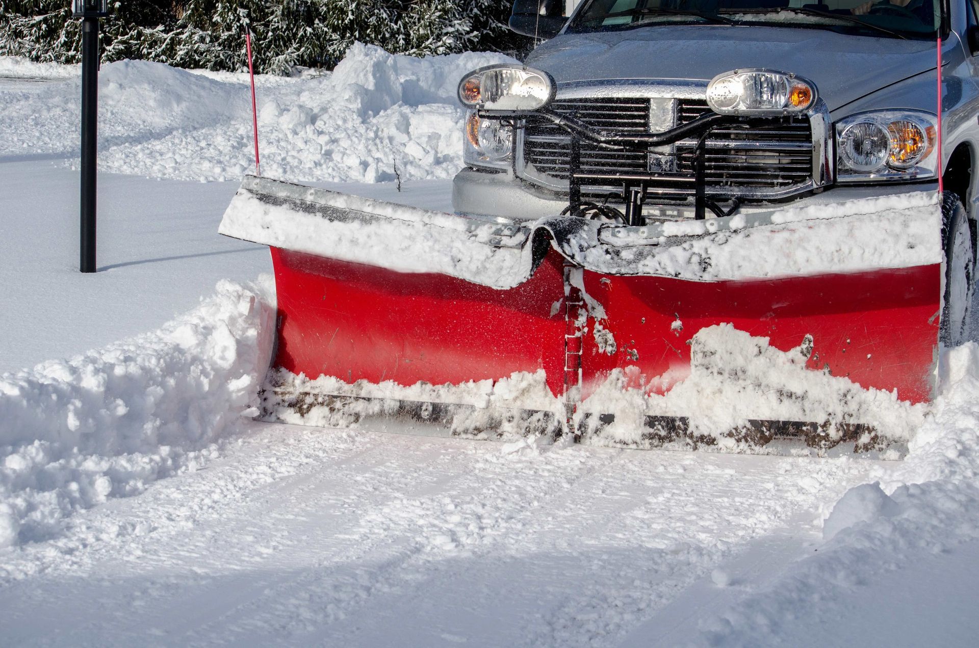 a silver truck with a red snow plow on it