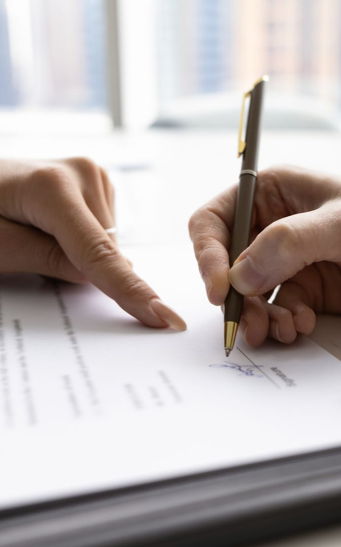 A woman in a white dress is standing in front of a tall building.