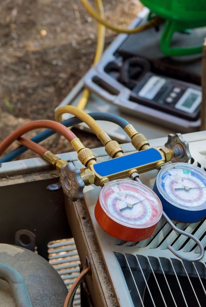 A close up of a refrigerator with gauges attached to it.