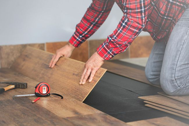 Worker Hands Installing Wood Floor — Lynnwood, WA — Fuentes Hardwood Floors