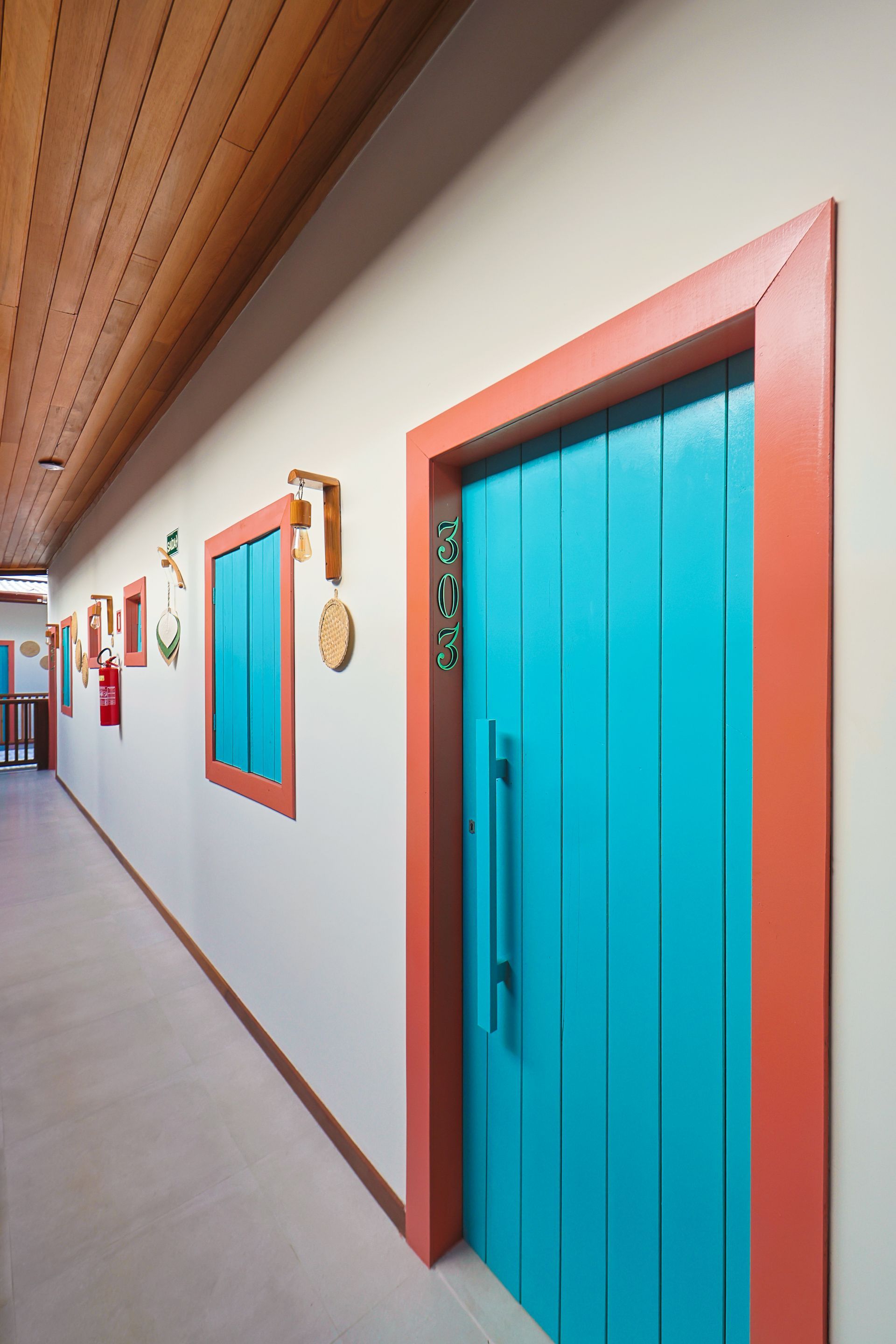 Um corredor com uma porta azul e um acabamento vermelho