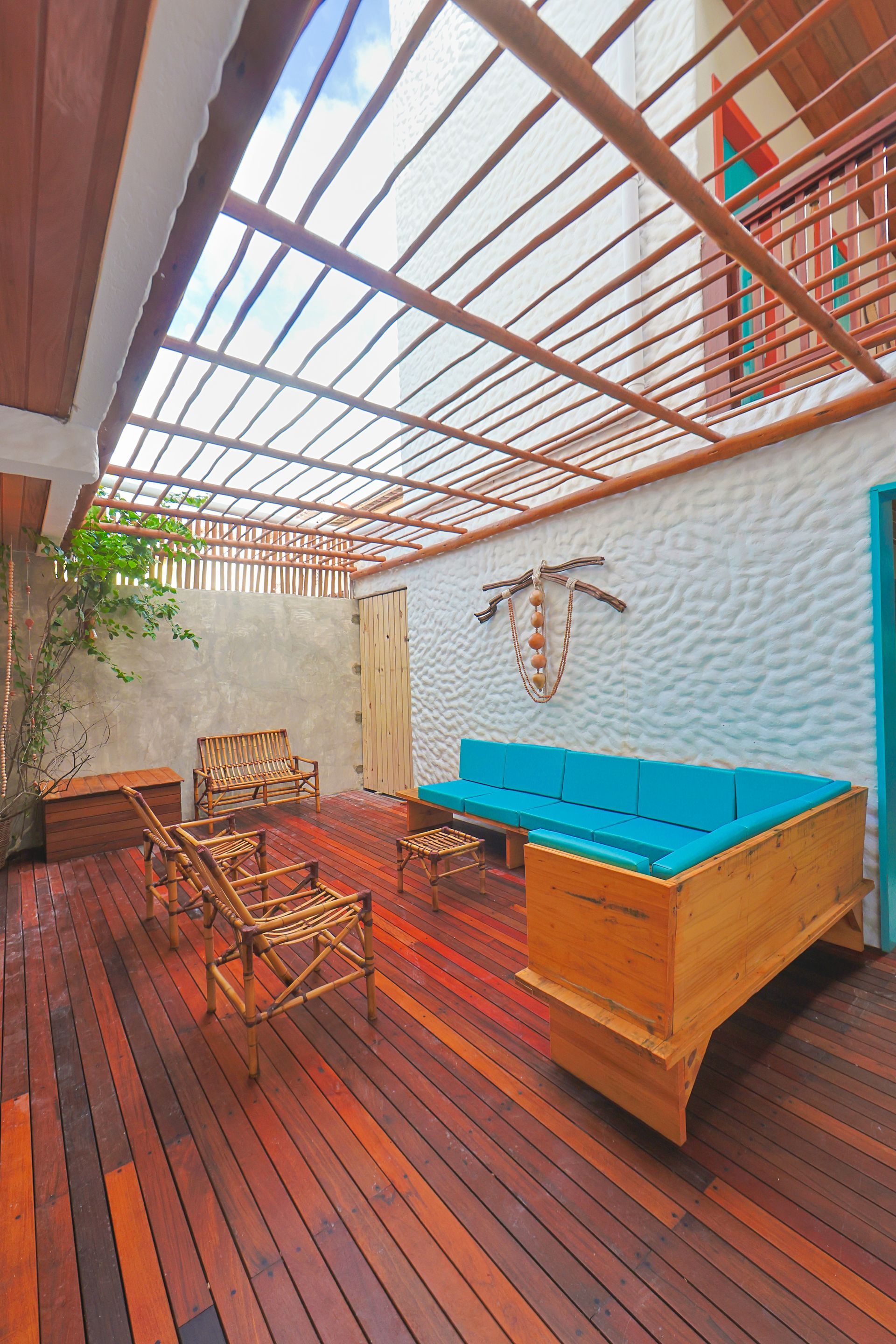 Há um deck de madeira com um sofá e cadeiras.