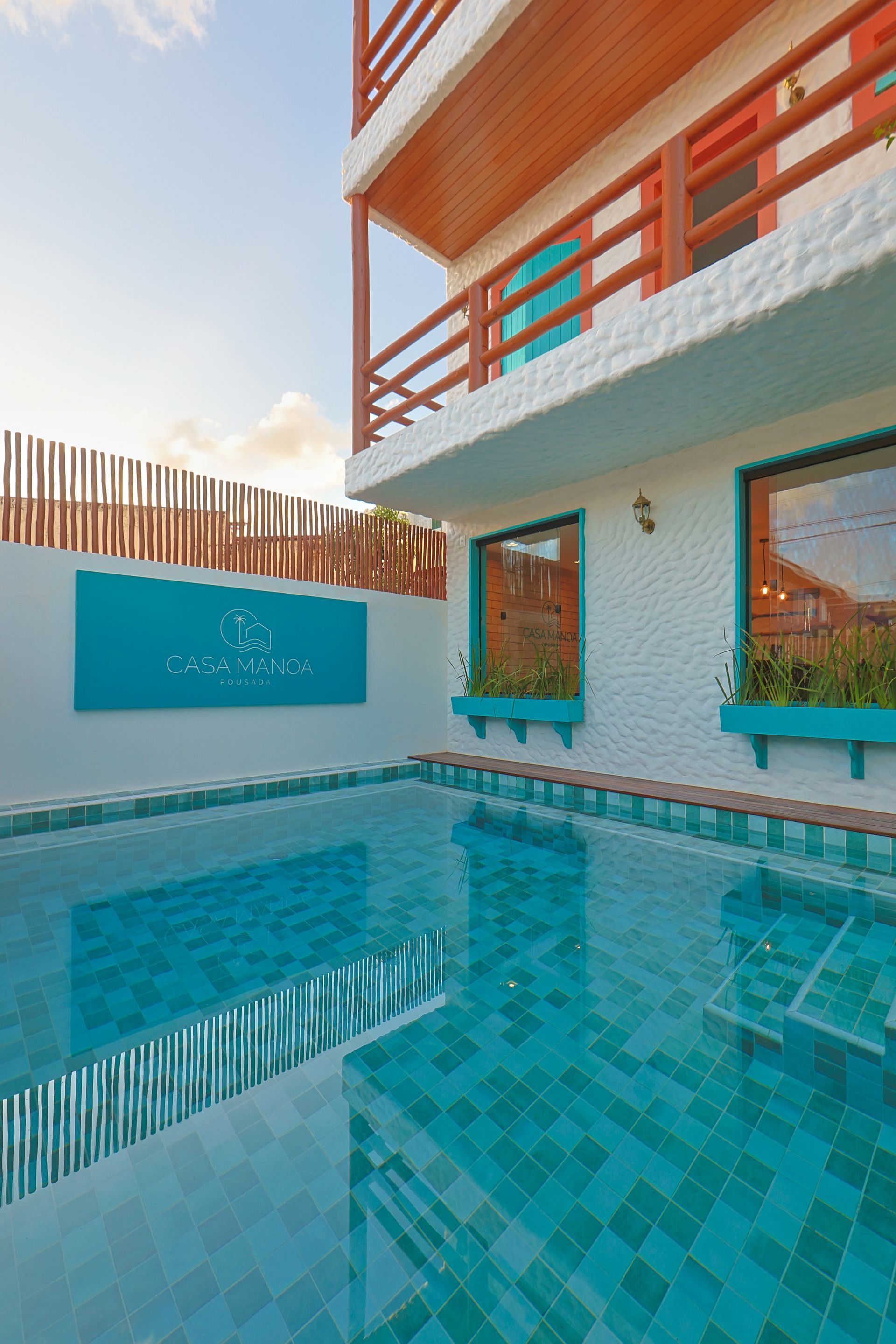 Uma grande piscina em frente a um prédio com varanda.