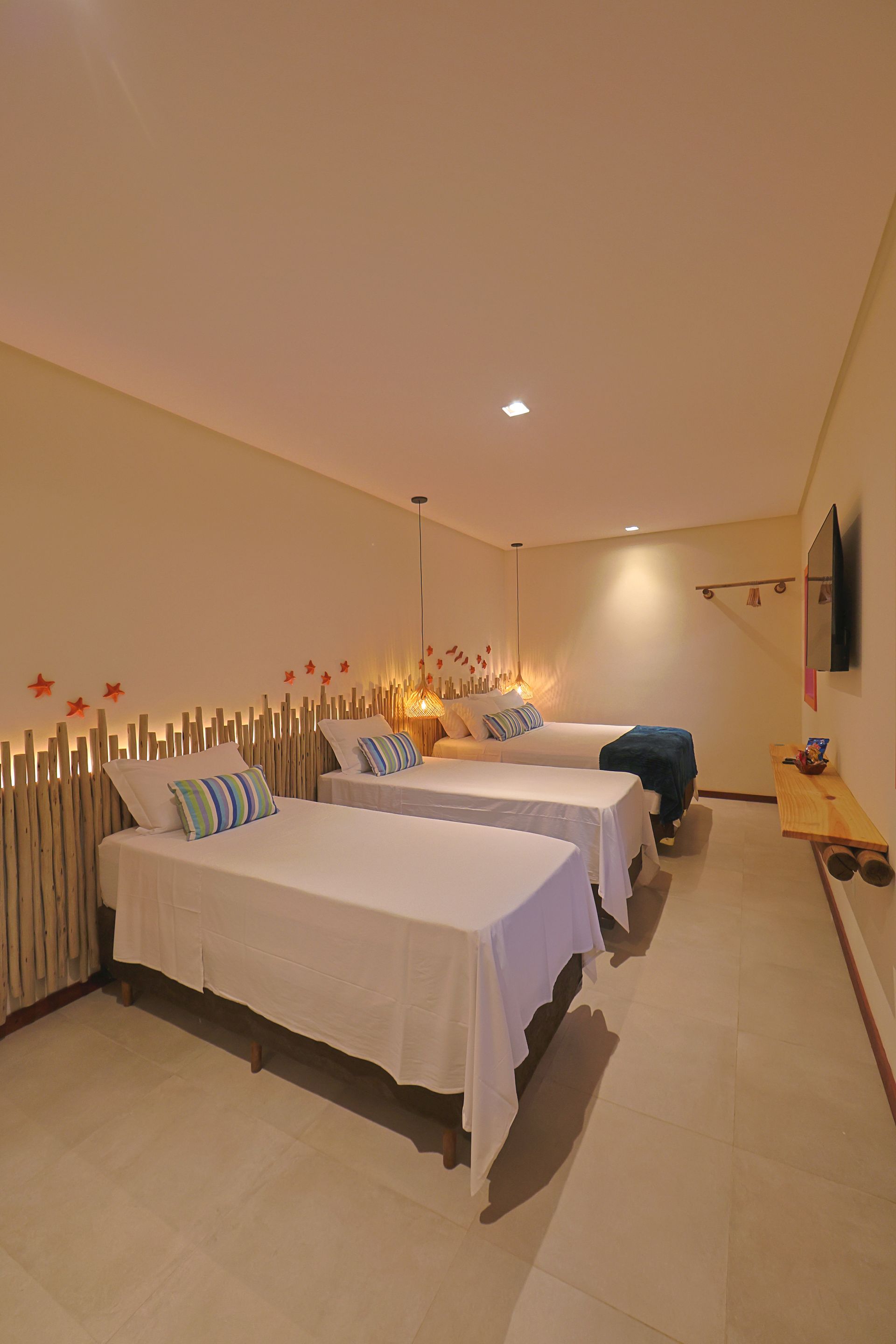 Um quarto de hotel com duas camas e uma TV de tela plana.