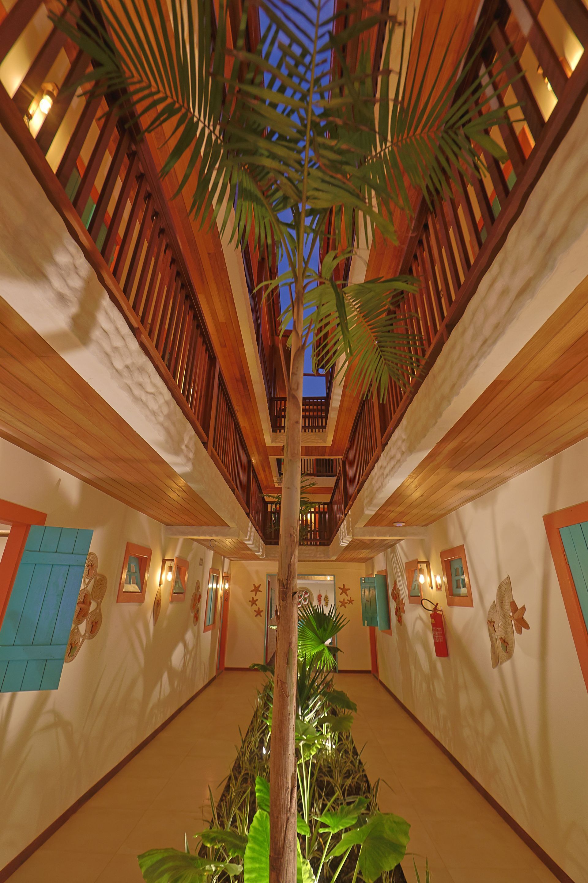 Um longo corredor com uma palmeira no meio