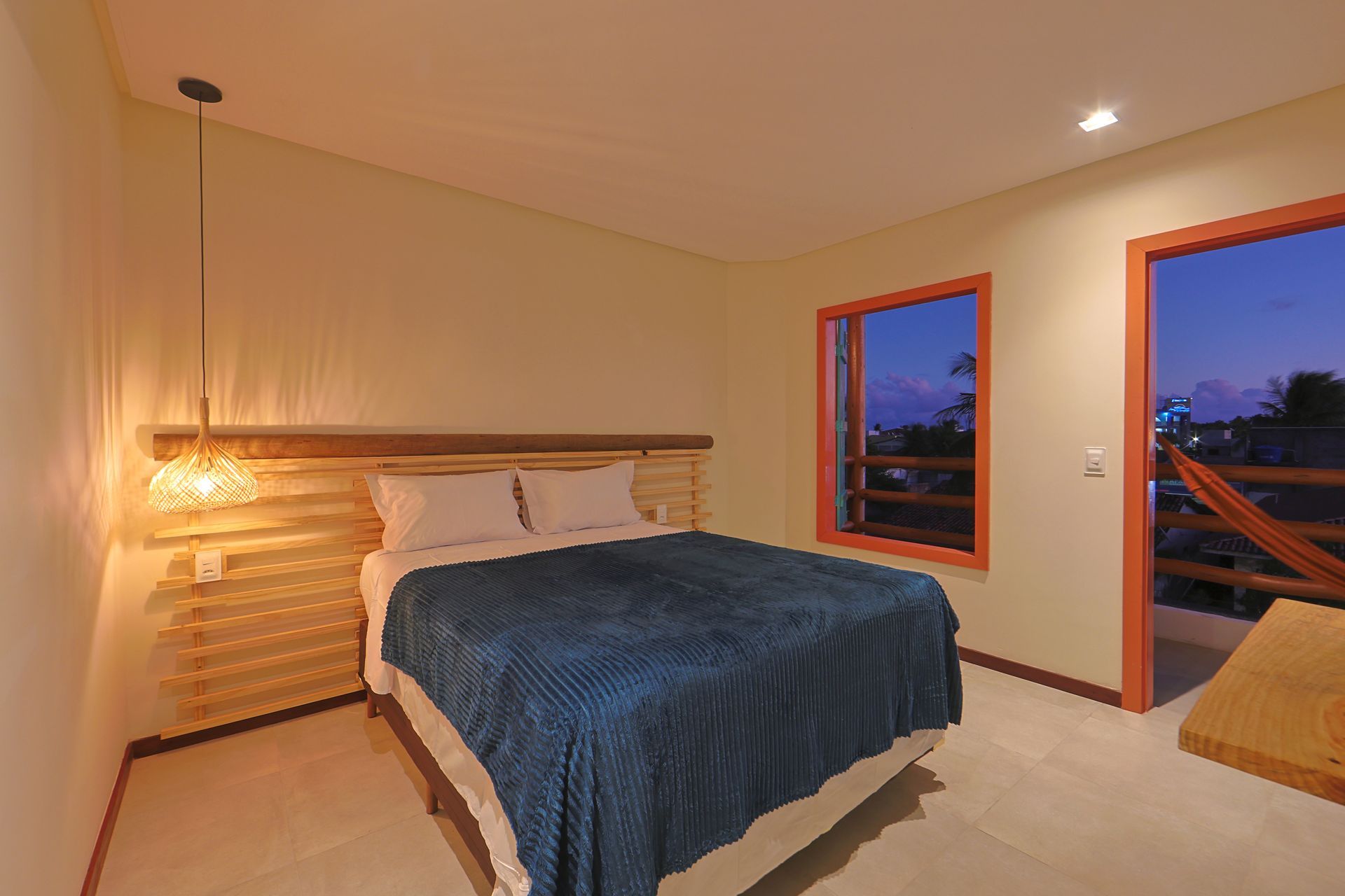 Um quarto com uma cama king size e duas janelas.