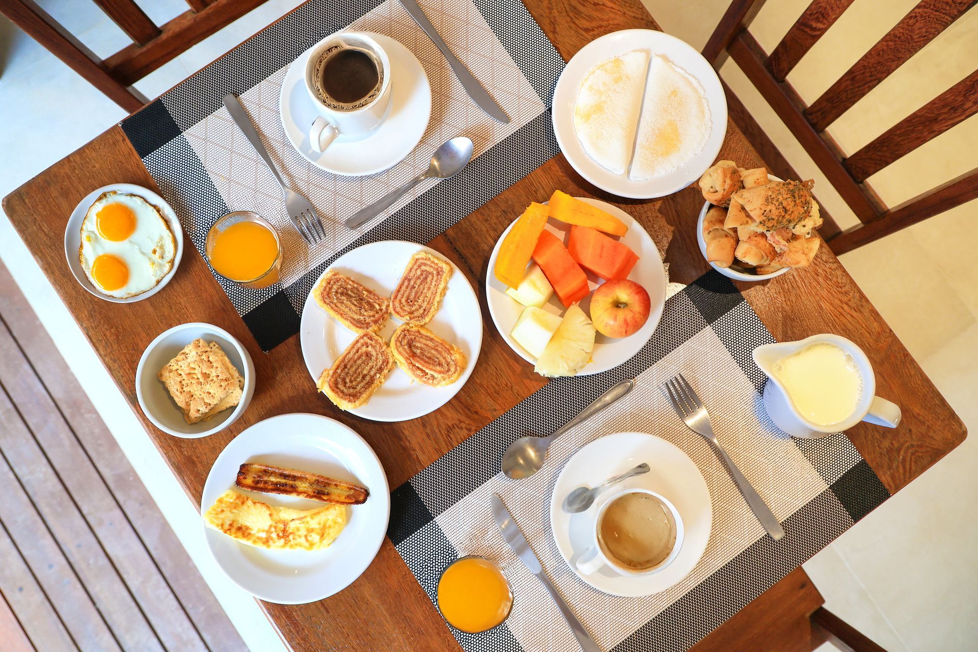 Uma mesa de madeira coberta com pratos de comida e bebidas.