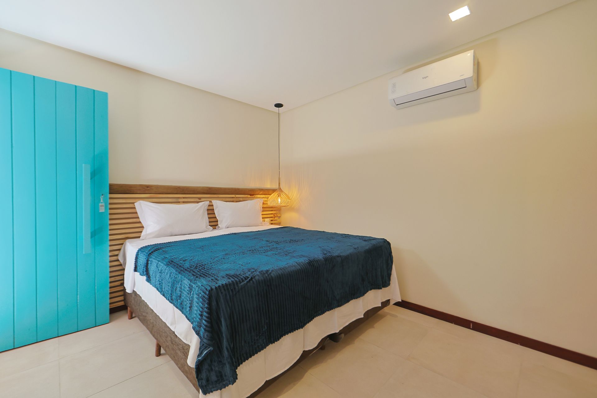 Um quarto com uma cama king size e um guarda-roupa azul.