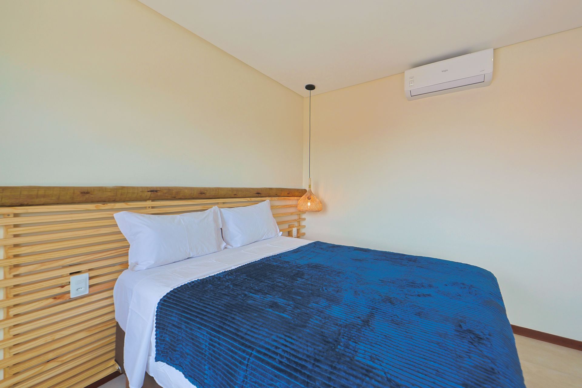 Um quarto com uma cama grande e uma cabeceira de madeira.