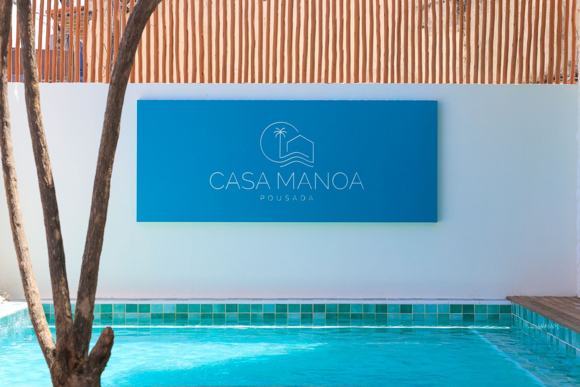 Uma piscina com uma placa na parede que diz casa manga