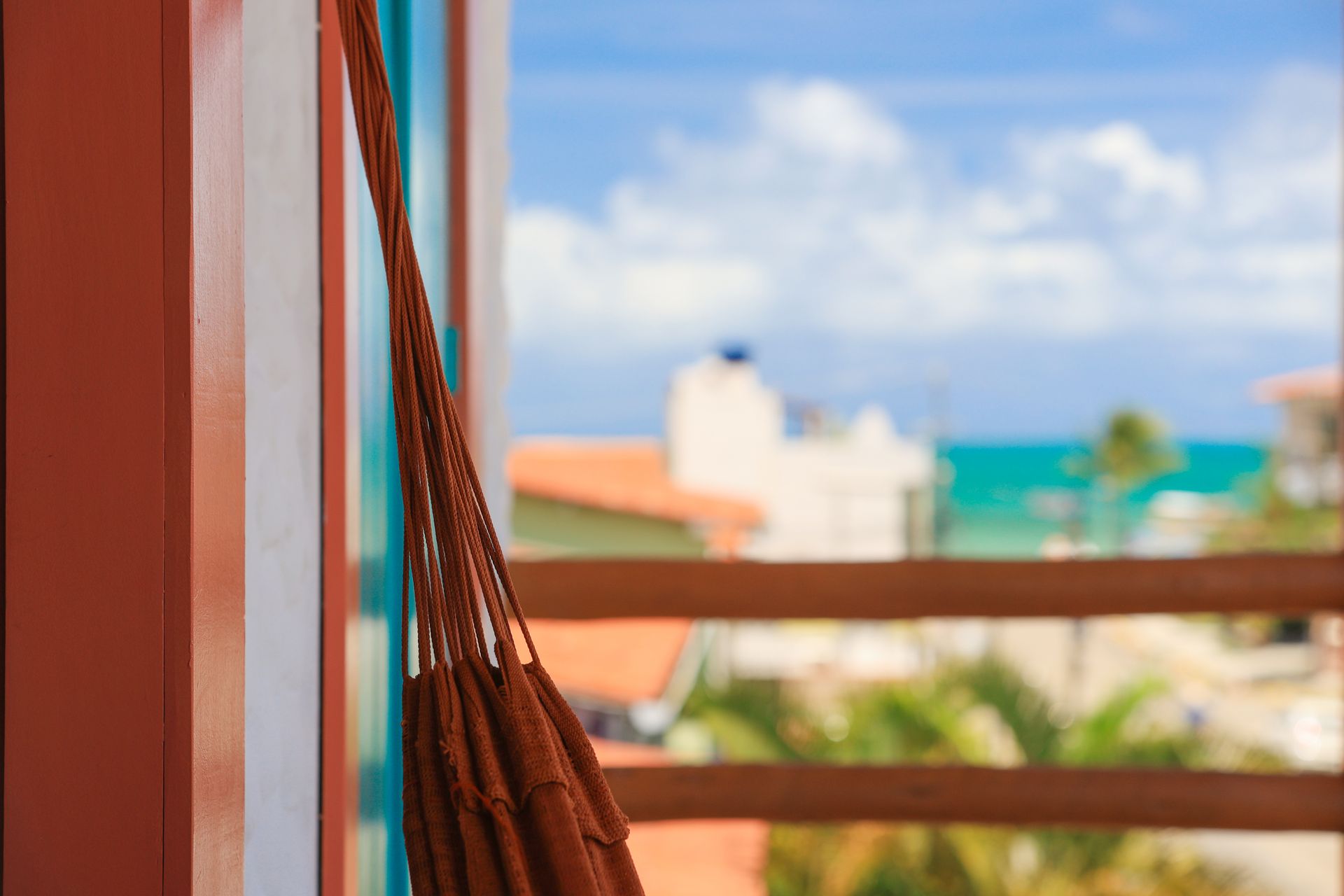 Uma rede está pendurada em uma janela com vista para o oceano.